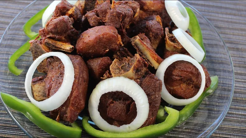 Platter of Haitian fried turkey (kodenn fri) with onions and green peppers